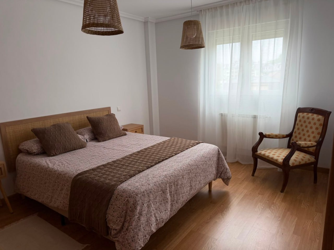 Dormitorio principal con cama doble y luz natural