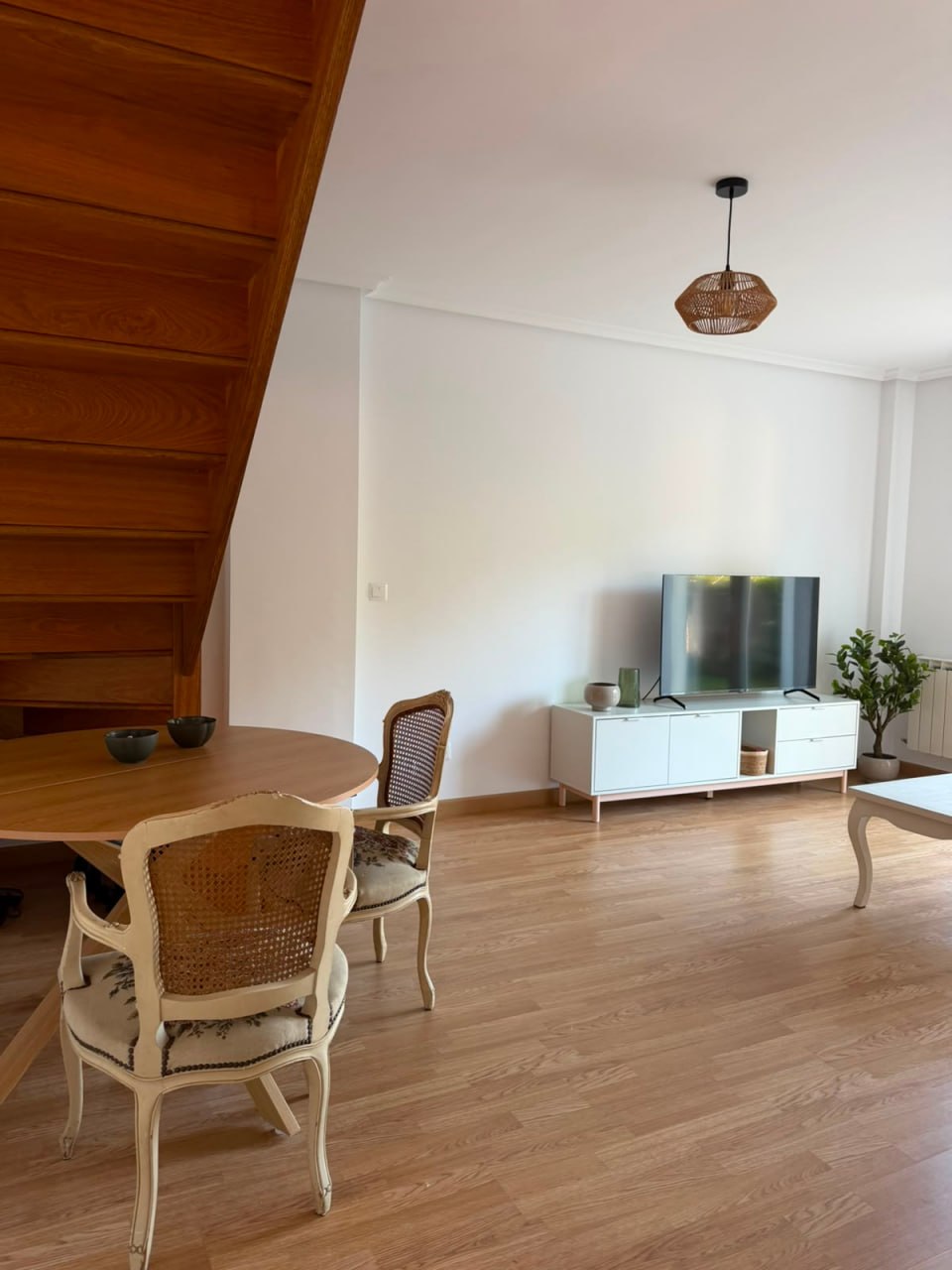 Salón comedor del dúplex con la escalera de madera